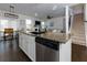 Open kitchen with stainless steel appliances, granite countertops, and a view of the stairs at 4675 Dandelion Way, Cumming, GA 30040