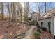 A stone path leads through the natural, wooded backyard of this lovely home at 90 Lakeside Dr, Hiram, GA 30141