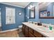 Bright bathroom featuring double sinks, wood cabinets, and a large window for natural light at 90 Lakeside Dr, Hiram, GA 30141