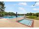 Large swimming pool with lounge chairs and umbrellas, surrounded by mature trees at 90 Lakeside Dr, Hiram, GA 30141