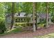 Charming, light green home with a welcoming front porch and lush, wooded surroundings on a naturally landscaped lot at 90 Lakeside Dr, Hiram, GA 30141
