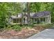 Charming, light green home with a welcoming front porch surrounded by mature trees and natural landscaping at 90 Lakeside Dr, Hiram, GA 30141