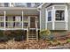 Inviting front porch with wood stairs, bay window and a cozy seating area, perfect for relaxing outdoors at 90 Lakeside Dr, Hiram, GA 30141