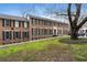 Traditional brick apartment building with black shutters and mature trees lining the front yard at 1101 Collier Nw Rd # U6, Atlanta, GA 30318