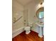 Bright bathroom features a pedestal sink, wood flooring, and a shower-tub combo with accessibility bars at 11365 Donnington Dr, Duluth, GA 30097