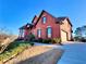 Spacious two-story red brick home with attached garage and a well-maintained lawn at 11365 Donnington Dr, Duluth, GA 30097