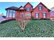 Charming red brick two-story home with manicured lawn, dark shutters, and a bay window at 11365 Donnington Dr, Duluth, GA 30097