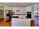 Bright kitchen with stainless steel refrigerator, white cabinetry, and central island sink at 11365 Donnington Dr, Duluth, GA 30097