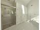 Bright main bathroom with a glass shower, soaking tub, and tiled floor at 11365 Donnington Dr, Duluth, GA 30097