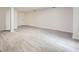 Open basement floor with light gray wood floors, white walls, and view of a closed white door at 140 Grosvenor Pl, Atlanta, GA 30328