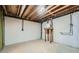Unfinished basement area showing exposed pipes, electrical connections, and a wooden table at 140 Grosvenor Pl, Atlanta, GA 30328