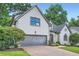 Charming home featuring a two-car garage, brick driveway, and lush green landscaping at 140 Grosvenor Pl, Atlanta, GA 30328