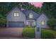 Charming two-story home with a well-manicured lawn, stone accents, and a brick driveway at 140 Grosvenor Pl, Atlanta, GA 30328