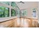 Bright sunroom with hardwood floors, large windows, and an exterior door leading to a patio at 140 Grosvenor Pl, Atlanta, GA 30328