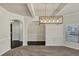 Neutral dining area with arched entranceway, decorative chandelier, wainscoting and hardwood floors at 3777 Shady Maple Dr, Lithonia, GA 30038