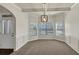 Inviting dining room with neutral carpet, wainscoting, modern chandelier, and ample natural light at 3777 Shady Maple Dr, Lithonia, GA 30038