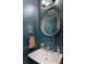 Contemporary powder room with round mirror and designer fixtures at 411 Johnson Ct, Alpharetta, GA 30009