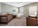 Cozy Bedroom featuring a wooden crib, comfortable armchair, and neutral decor at 411 Johnson Ct, Alpharetta, GA 30009
