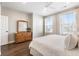 Spacious bedroom featuring a large dresser with mirror, two windows, and luxury vinyl plank flooring at 411 Johnson Ct, Alpharetta, GA 30009