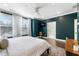 The large, sunny main bedroom features beautiful trim work, a ceiling fan, and a wall-mounted television at 411 Johnson Ct, Alpharetta, GA 30009