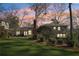 Backyard view of home at sunset featuring artificial turf, patio, deck, and mature trees at 3902 Sheldon Ne Dr, Atlanta, GA 30342