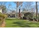 Backyard view of home featuring artificial turf, patio, and mature trees at 3902 Sheldon Ne Dr, Atlanta, GA 30342