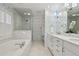 Elegant bathroom with a soaking tub, glass-enclosed shower, and double vanity with white marble counters at 3902 Sheldon Ne Dr, Atlanta, GA 30342