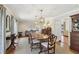 Elegant dining room featuring a long wood table set for six, beautiful pendant lights, and hardwood floors at 3902 Sheldon Ne Dr, Atlanta, GA 30342