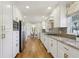 Bright, galley kitchen with stainless steel appliances and granite counters overlooks a casual dining area at 3902 Sheldon Ne Dr, Atlanta, GA 30342