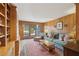 Comfortable living room featuring wood paneled walls, built-in bookshelves, comfortable seating, and outdoor access at 3902 Sheldon Ne Dr, Atlanta, GA 30342