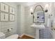 Stylish powder room features patterned wallpaper, pedestal sink, decorative mirror, and hardwood floors at 3902 Sheldon Ne Dr, Atlanta, GA 30342