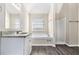 Well-lit bathroom featuring a soaking tub and shower stall at 4260 Mason Creek Rd, Winston, GA 30187