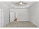Spacious, carpeted bedroom with a fan and decorative tray ceiling at 175 Basil St, Cumming, GA 30040