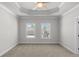 Spacious carpeted bedroom with a decorative tray ceiling and two windows at 175 Basil St, Cumming, GA 30040