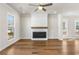 A well-lit living room with hardwood floors and a white brick fireplace with a wooden mantel at 175 Basil St, Cumming, GA 30040