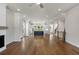 Spacious living room with hardwood floors, brick fireplace, and open access to the kitchen and staircase at 175 Basil St, Cumming, GA 30040