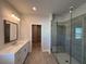 Luxurious bathroom with a glass shower, double vanity, and modern lighting fixtures at 175 Basil St, Cumming, GA 30040