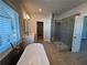 Open-concept bathroom featuring a soaking tub, glass shower, and double vanity sink at 175 Basil St, Cumming, GA 30040