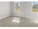 Bright bedroom featuring neutral carpeting and two large windows with natural light at 175 Basil St, Cumming, GA 30040