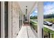 Inviting front porch featuring brick flooring, white columns and black metal railings at 175 Basil St, Cumming, GA 30040