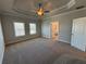 Bright main bedroom featuring carpet, ceiling fan, and an en-suite bathroom with natural light at 175 Basil Street St, Cumming, GA 30040