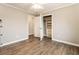 Bedroom with laminate flooring shows an open closet with built in storage shelves and drawers at 3165 Pucketts Mill Rd, Buford, GA 30519