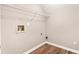 An efficiently designed laundry room with hardwood floors, utility connections, and convenient wire shelving at 3165 Pucketts Mill Rd, Buford, GA 30519