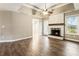 Bright living room featuring hardwood floors, a stone fireplace, and a tray ceiling with a ceiling fan at 3165 Pucketts Mill Rd, Buford, GA 30519