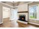 Living room showcasing a stone fireplace, wood floors, and a view into the dining area at 3165 Pucketts Mill Rd, Buford, GA 30519