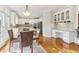 Well-lit kitchen and dining area featuring white cabinetry, hardwood floors, and a modern desk nook at 3468 Pine Grove Dr, Douglasville, GA 30135