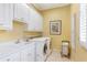 Bright laundry room with white cabinets, sink, washer and dryer, and shuttered window at 4610 Wynmeade Ne Park, Marietta, GA 30067