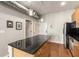 Kitchen island featuring wooden cabinets, a black countertop, pendant lights, and hardwood floors at 5300 Peachtree Rd # 1311, Atlanta, GA 30341