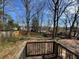 The backyard is viewed from the deck which features mature trees and a new fence at 542 Sugar Hill Nw Dr, Marietta, GA 30060
