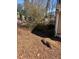 Backyard with sparse foliage and leaves on the ground with a small bale of hay at 542 Sugar Hill Nw Dr, Marietta, GA 30060